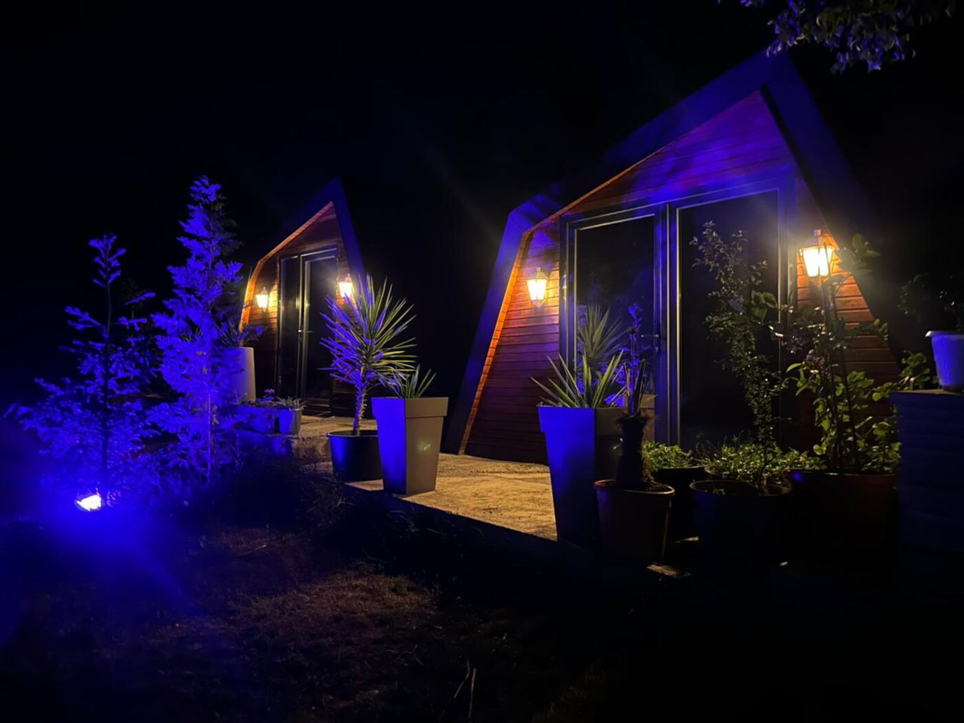 Glamping bungalow accommodation at Teddy Camp Kosovo, lit up at night
